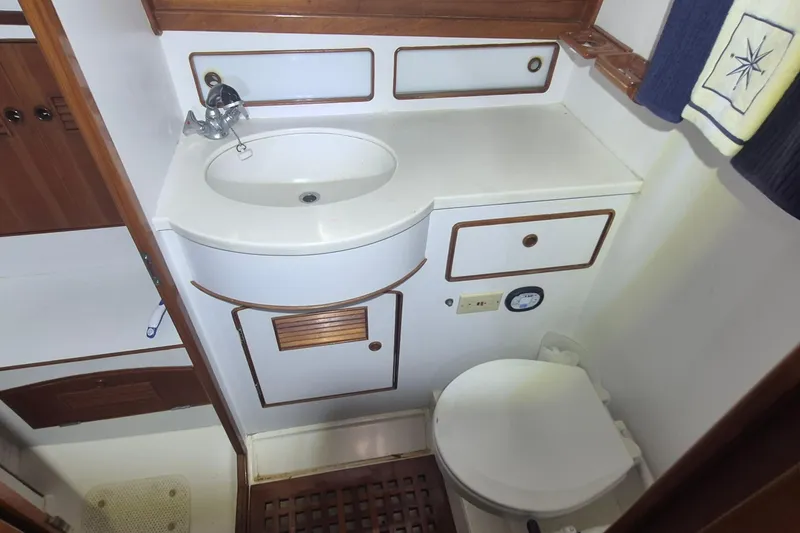 Slide: The Image of 1990 Little Harbor Express yacht bathroom with sink, toilet, and wooden accents. - 26