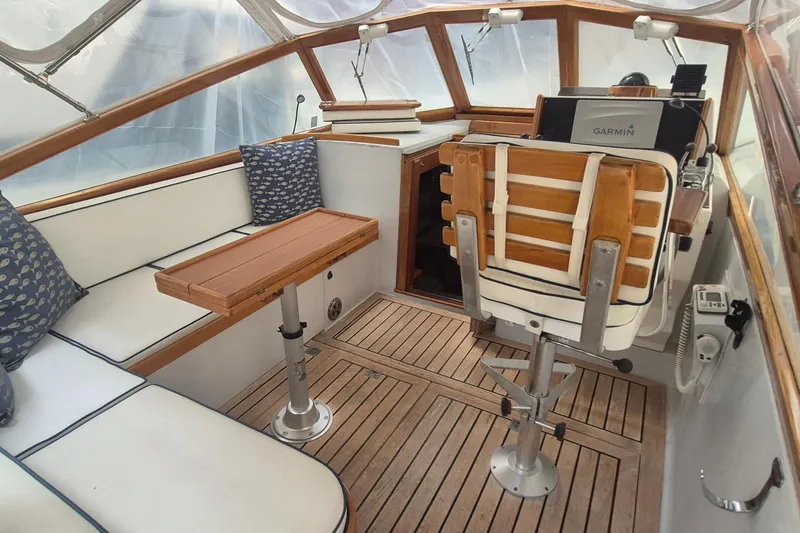 Slide: The Image of 1990 Little Harbor Express boat interior with wooden seating, table, and Garmin navigation system. - 3
