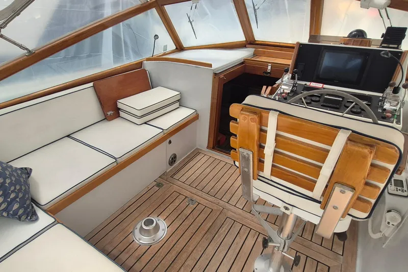 Slide: The Image of 1990 Little Harbor Express boat interior with wooden helm, cushioned seating, and navigation equipment. - 5