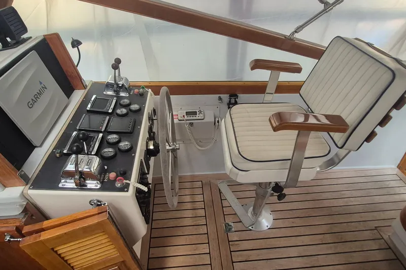 Slide: The Image of 1990 Little Harbor Express helm with Garmin navigation, classic controls, and cushioned captain's chair. - 6
