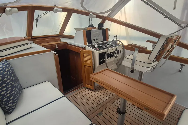 Slide: The Image of 1990 Little Harbor Express boat interior with helm, wooden accents, and seating area. - 7