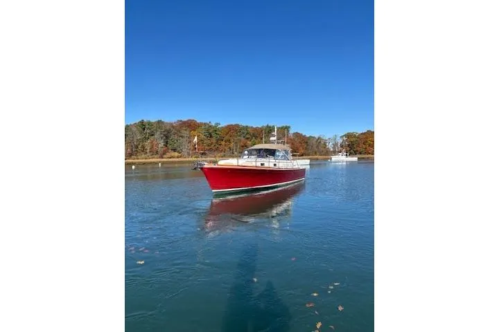 Slide: The Image of 1998 Grand Banks 38 Eastbay EX cruising on a serene lake under a clear blue sky. - 12