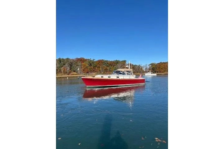 Slide: The Image of 1998 Grand Banks 38 Eastbay EX boat on calm water, clear blue sky background. - 13