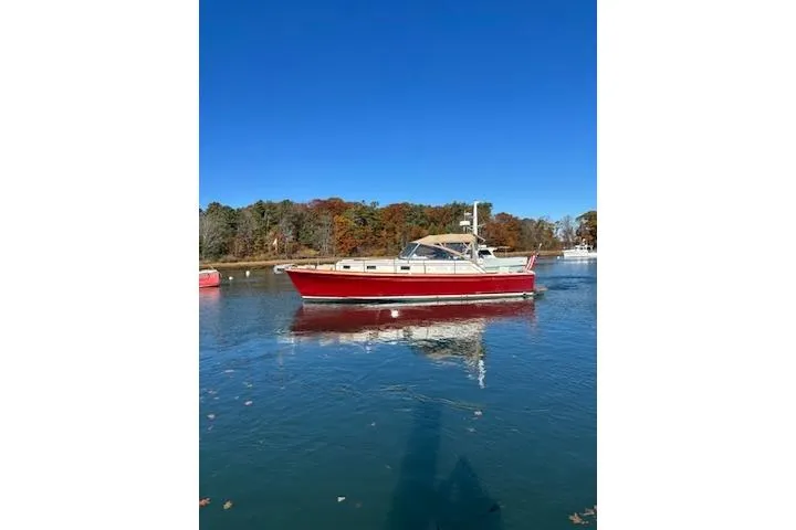 Slide: The Image of 1998 Grand Banks 38 Eastbay EX boat on calm water, clear blue sky background. - 15