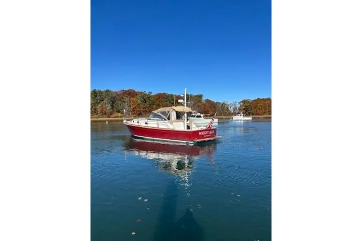 Slide: The Image of 1998 Grand Banks 38 Eastbay EX boat on calm water with autumn trees in background. - 18