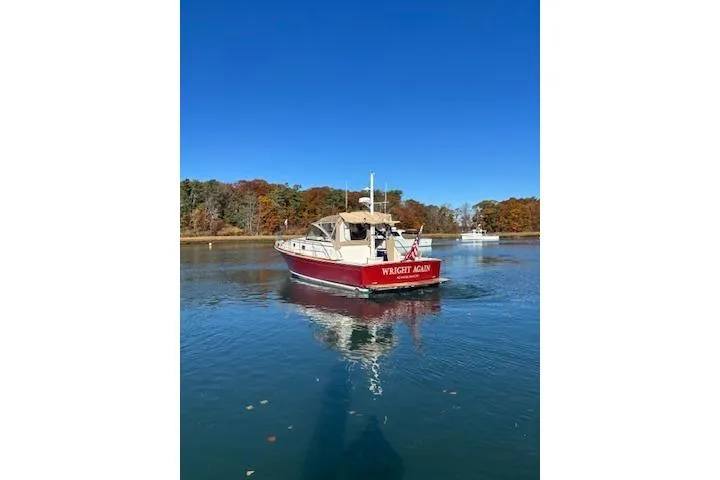 Slide: The Image of 1998 Grand Banks 38 Eastbay EX boat on calm water, clear blue sky background. - 19