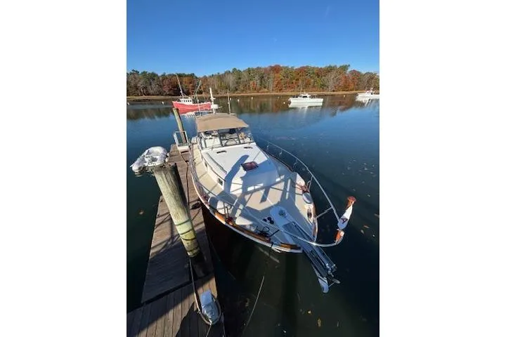 Slide: The Image of 1998 Grand Banks 38 Eastbay EX docked on a serene lake with autumn foliage. - 2