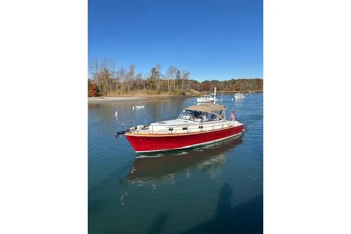 Slide: The Image of 1998 Grand Banks 38 Eastbay EX cruising on a serene river under a clear blue sky. - 30