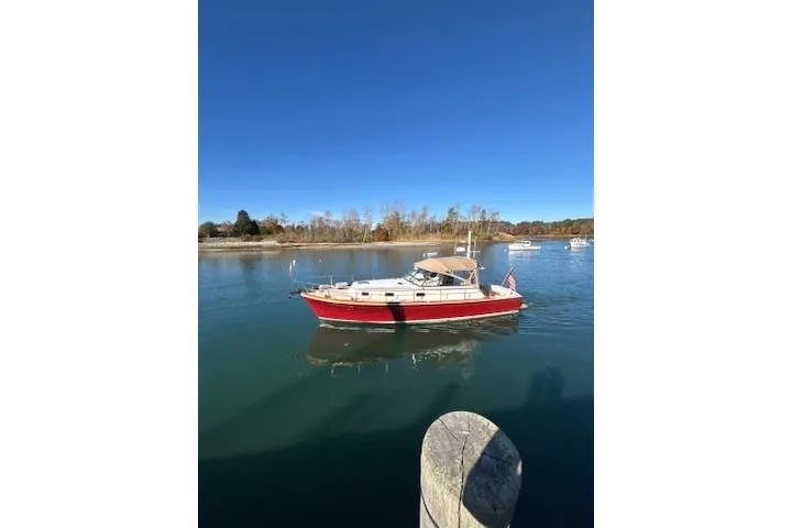 Slide: The Image of 1998 Grand Banks 38 Eastbay EX boat on calm water under clear blue sky. - 32