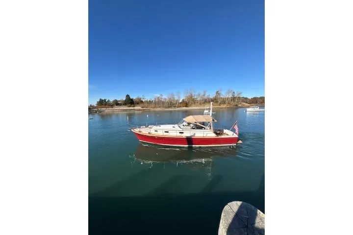 Slide: The Image of 1998 Grand Banks 38 Eastbay EX cruising on calm waters under a clear blue sky. - 33