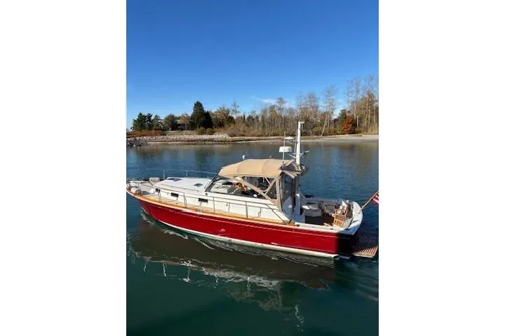 Slide: The Image of 1998 Grand Banks 38 Eastbay EX cruising on a calm lake under clear blue skies. - 34
