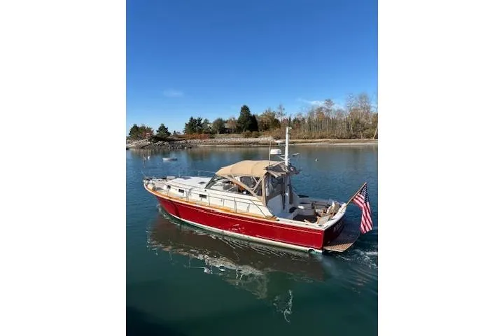Slide: The Image of 1998 Grand Banks 38 Eastbay EX cruising on a calm lake under a clear blue sky. - 35
