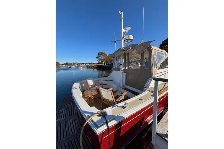 Slide: The Image of 1998 Grand Banks 38 Eastbay EX docked, featuring a spacious deck and clear blue sky. - 5