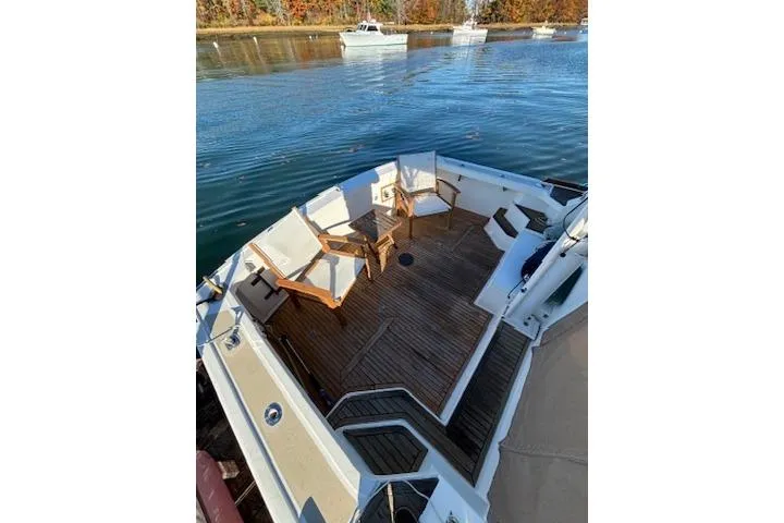 Slide: The Image of 1998 Grand Banks 38 Eastbay EX boat with wooden deck and seating area on calm water. - 6