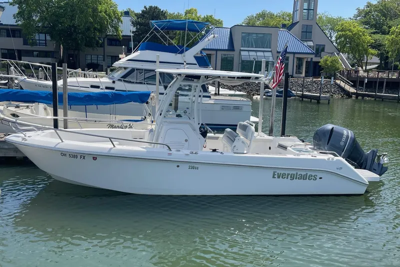 The Image of 2018 Everglades 230 Center Console boat docked in a marina, featuring a Yamaha outboard motor. - 0