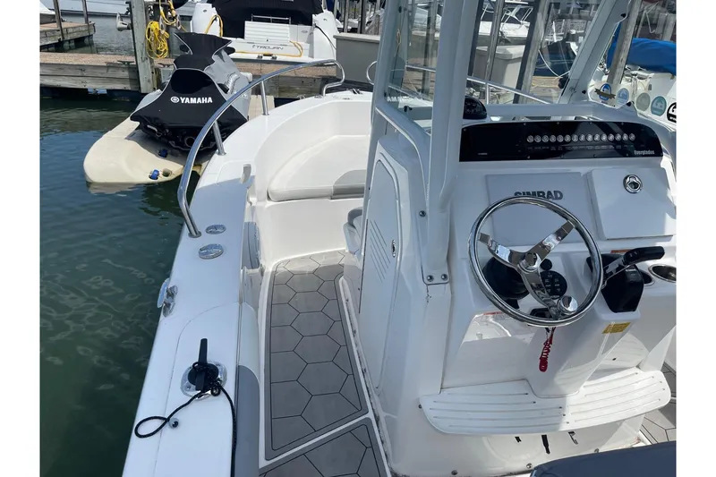 Slide: The Image of 2018 Everglades 230 Center Console boat with steering wheel and control panel at marina. - 14