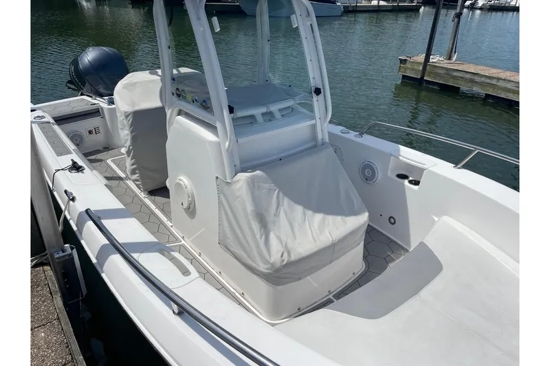 Slide: The Image of 2018 Everglades 230 Center Console boat docked, featuring covered seating and console. - 21