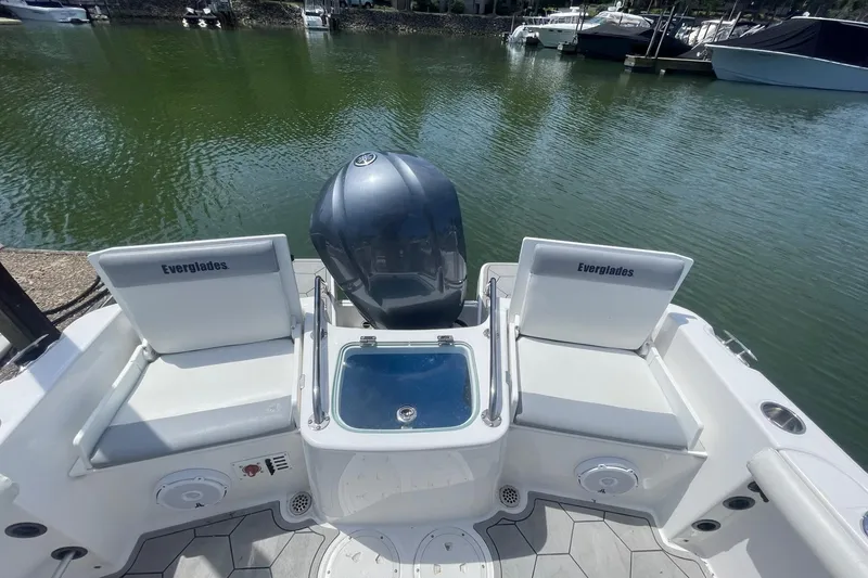 Slide: The Image of 2018 Everglades 230 Center Console boat with seating and motor, docked on calm water. - 4