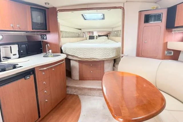 Slide: The Image of Interior of 2002 Chaparral 350 Signature yacht with kitchen, dining area, and bed. - 16