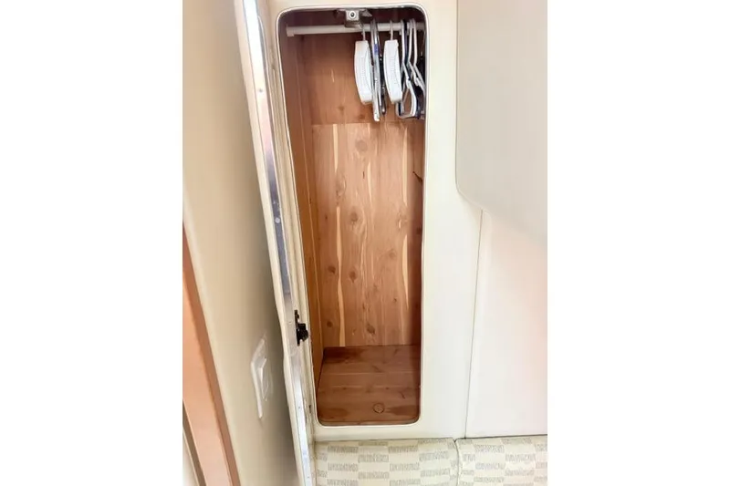 Slide: The Image of Wooden closet interior with hangers in a 2002 Chaparral 350 Signature boat. - 17