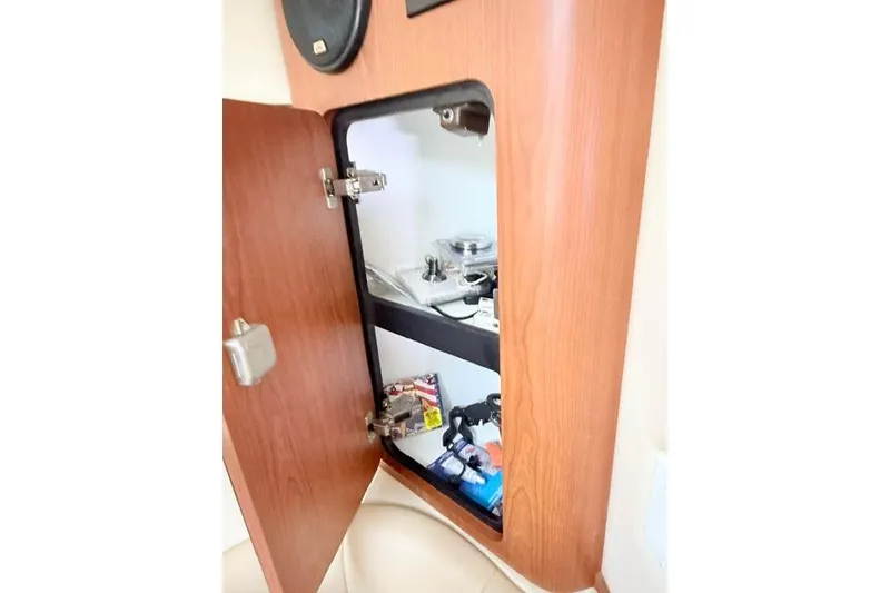 Slide: The Image of Open cabinet in 2002 Chaparral 350 Signature boat, showing storage shelves and items. - 21