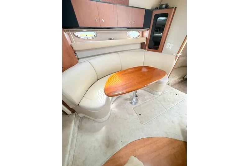 Slide: The Image of Interior of 2002 Chaparral 350 Signature yacht with curved seating and wooden table. - 25