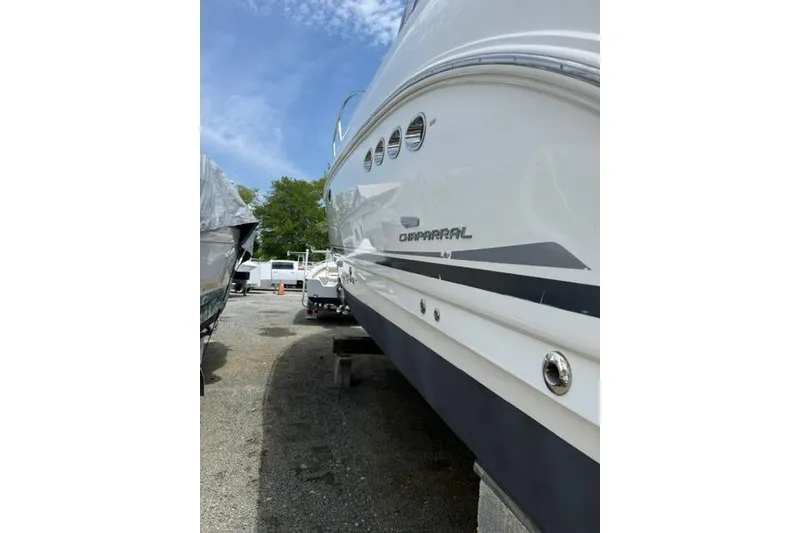 Slide: The Image of 2002 Chaparral 350 Signature boat side view, parked outdoors under blue sky. - 3