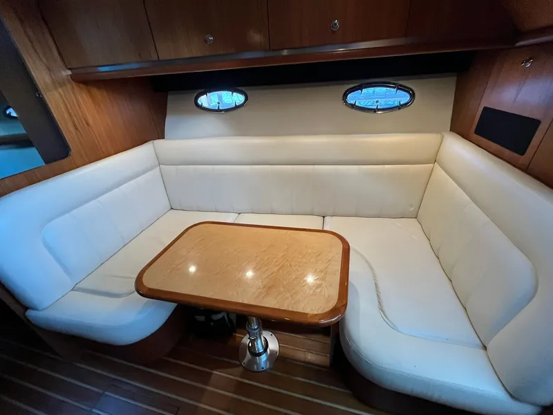 Slide: The Image of Interior of 2006 Tiara Yachts 3600 Open with white sofa and wooden table. - 26