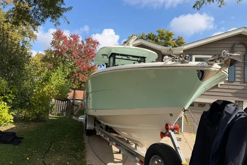 Slide: The Image of 2017 Robalo R302 Center Console boat on trailer in front of house. - 13
