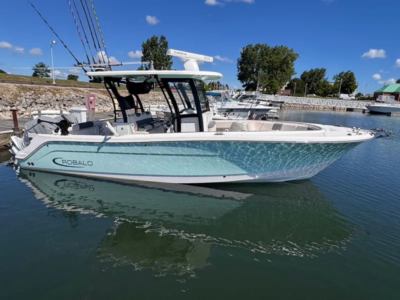 Slide: The Image of A Robalo R302 Center Console boat is docked in calm harbor waters. - 16
