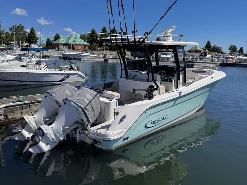 Slide: The Image of A Robalo R302 Center Console boat docked in a marina, surrounded by other boats. - 17