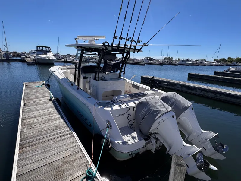 Slide: The Image of A Robalo R302 Center Console boat docked in a marina, equipped with two outboard engines. - 18