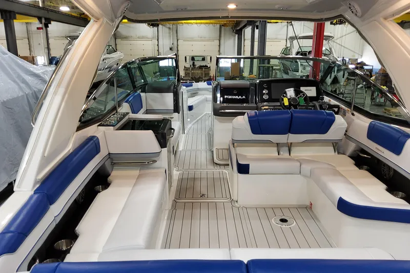 Slide: The Image of 2027 Formula 330 Crossover Bowrider OB interior with blue and white seating in a showroom. - 21