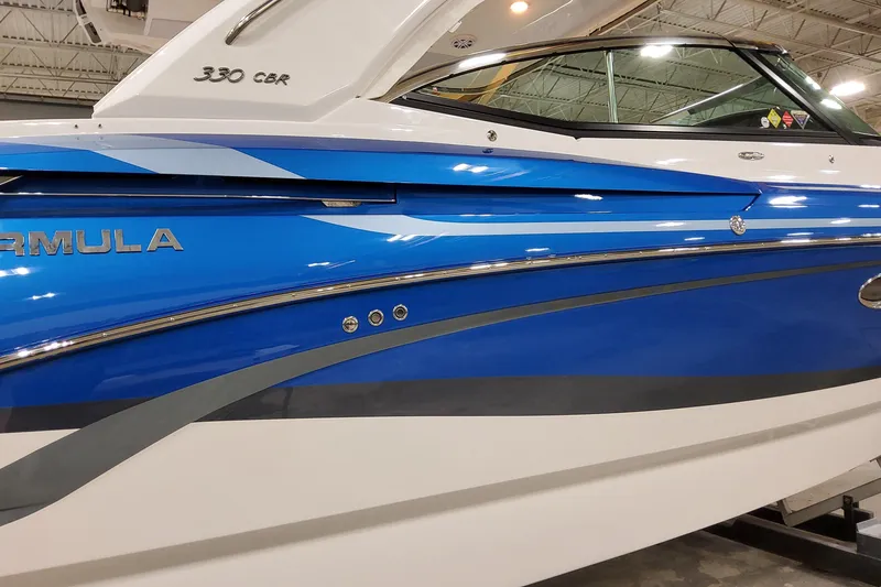Slide: The Image of 2027 Formula 330 Crossover Bowrider OB, sleek blue and white design in showroom. - 3