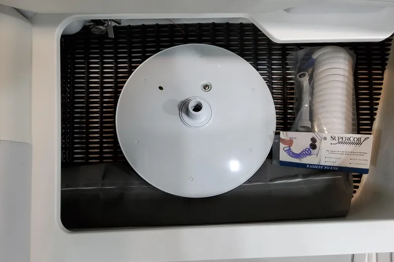 Slide: The Image of Storage compartment in a 2027 Formula 330 Crossover Bowrider OB with coiled hose and accessories. - 69