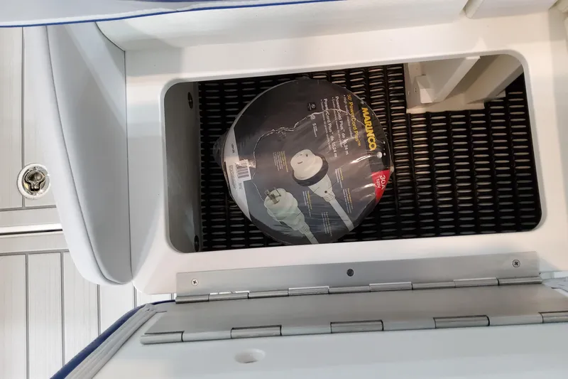 Slide: The Image of Storage compartment in 2027 Formula 330 Crossover Bowrider OB with coiled power cord. - 70