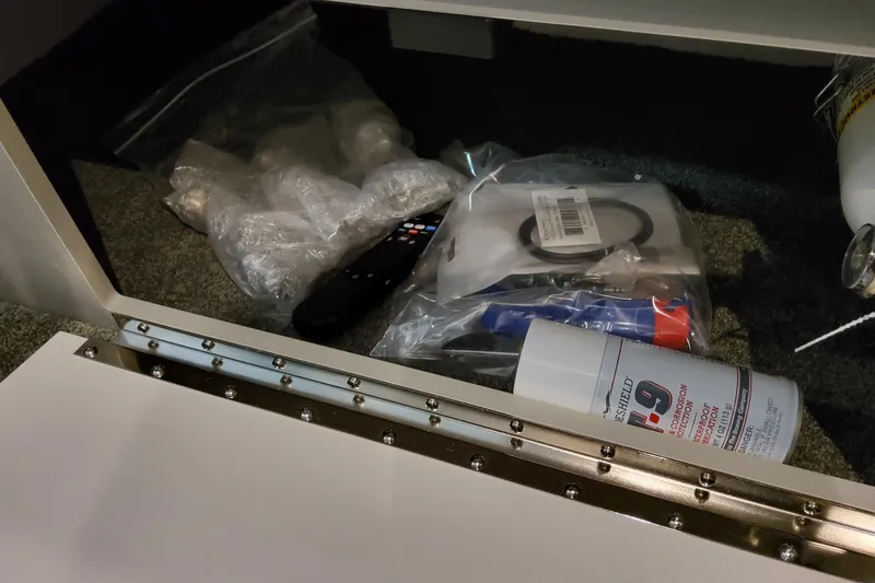 Slide: The Image of Storage compartment in a 2027 Formula 330 Crossover Bowrider OB with various maintenance items. - 85