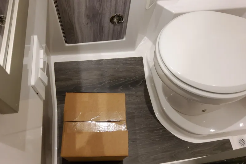 Slide: The Image of Bathroom area of a 2027 Formula 330 Crossover Bowrider OB with a cardboard box on the floor. - 86
