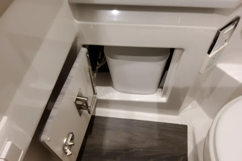 Slide: The Image of 2027 Formula 330 Crossover Bowrider OB bathroom storage with open cabinet and waste bin. - 89