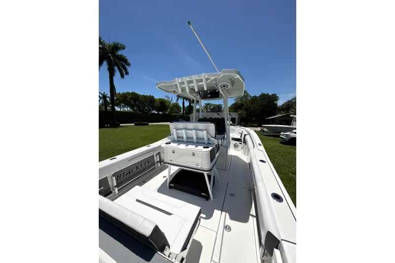 Slide: The Image of 2022 Blackfin 252 CC boat with seating and console, under clear blue sky. - 13