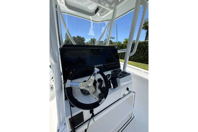 Slide: The Image of 2022 Blackfin 252 CC boat helm with steering wheel and control panel. - 14