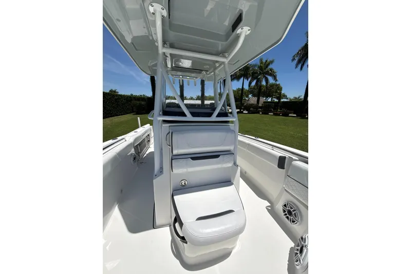 Slide: The Image of 2022 Blackfin 252 CC boat interior with seating and canopy, set against a sunny outdoor backdrop. - 16