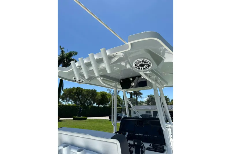 Slide: The Image of 2022 Blackfin 252 CC boat console with speakers and rod holders under clear blue sky. - 18