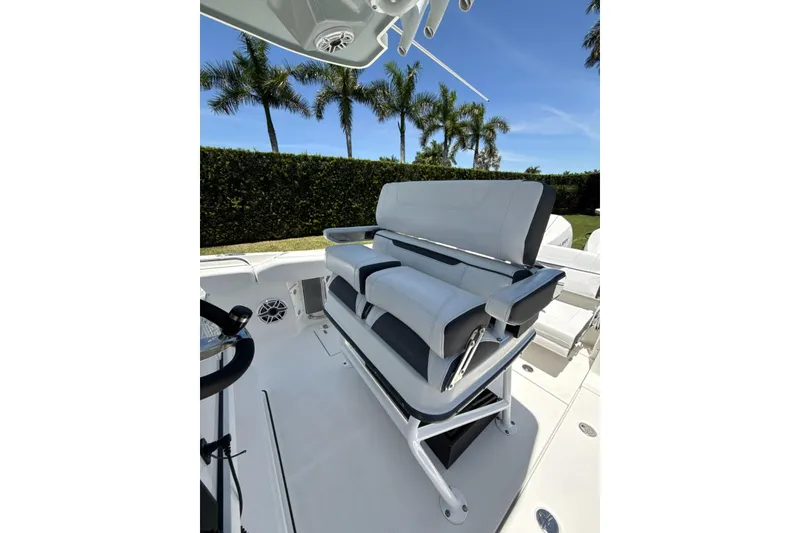 Slide: The Image of 2022 Blackfin 252 CC boat interior with sleek seating and palm trees in the background. - 20
