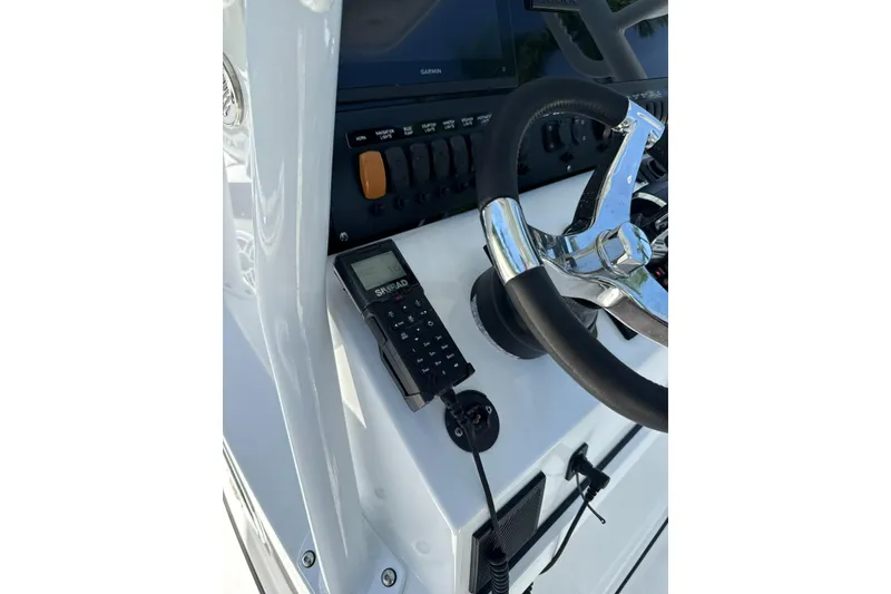Slide: The Image of 2022 Blackfin 252 CC boat helm with steering wheel and Simrad marine electronics. - 22