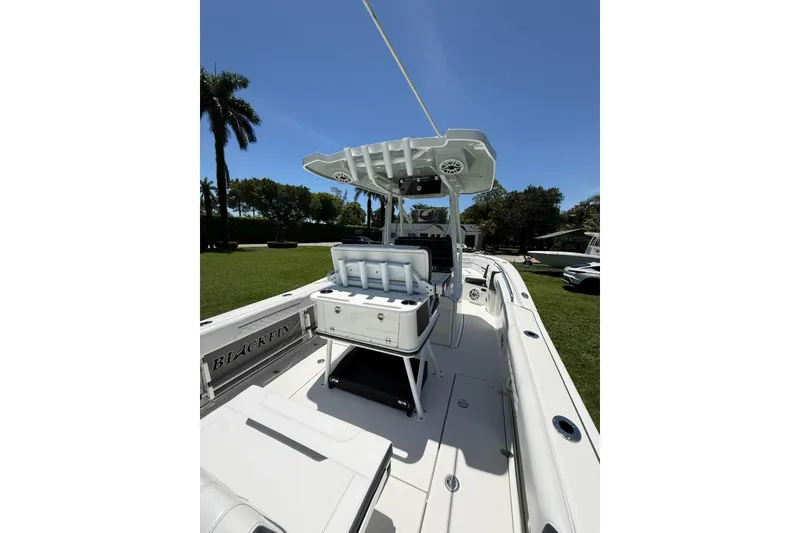 Slide: The Image of 2022 Blackfin 252 CC boat interior with seating and storage, under clear blue sky. - 24