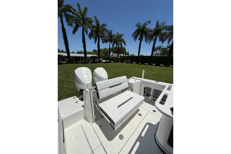 Slide: The Image of 2022 Blackfin 252 CC boat with dual Mercury engines, set against a backdrop of palm trees. - 28