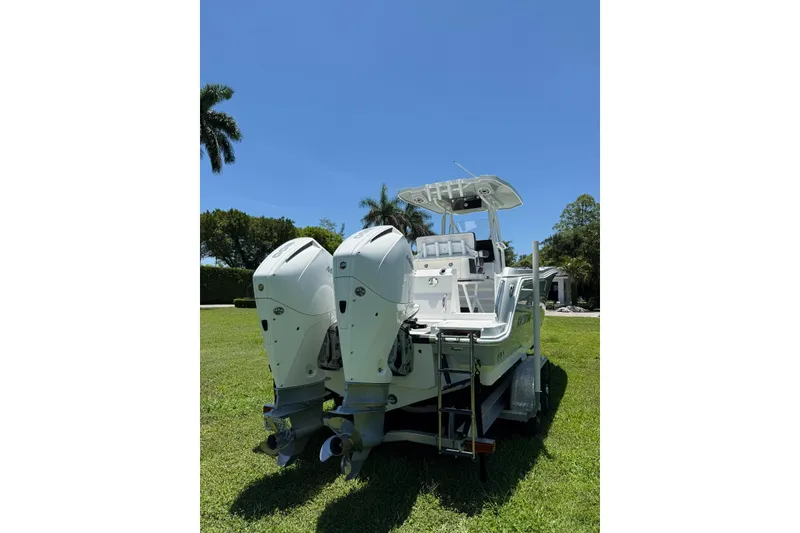 Slide: The Image of 2022 Blackfin 252 CC boat with dual outboard engines on a grassy lawn. - 7