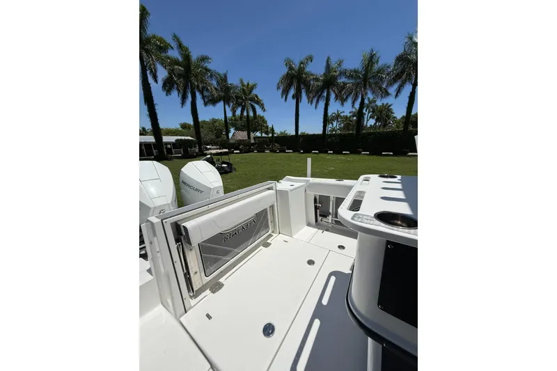 Slide: The Image of 2022 Blackfin 252 CC boat deck with palm trees in the background. - 8