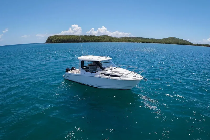 The Image of 2024 Boston Whaler 325 Conquest boat cruising on clear blue ocean waters. - 1